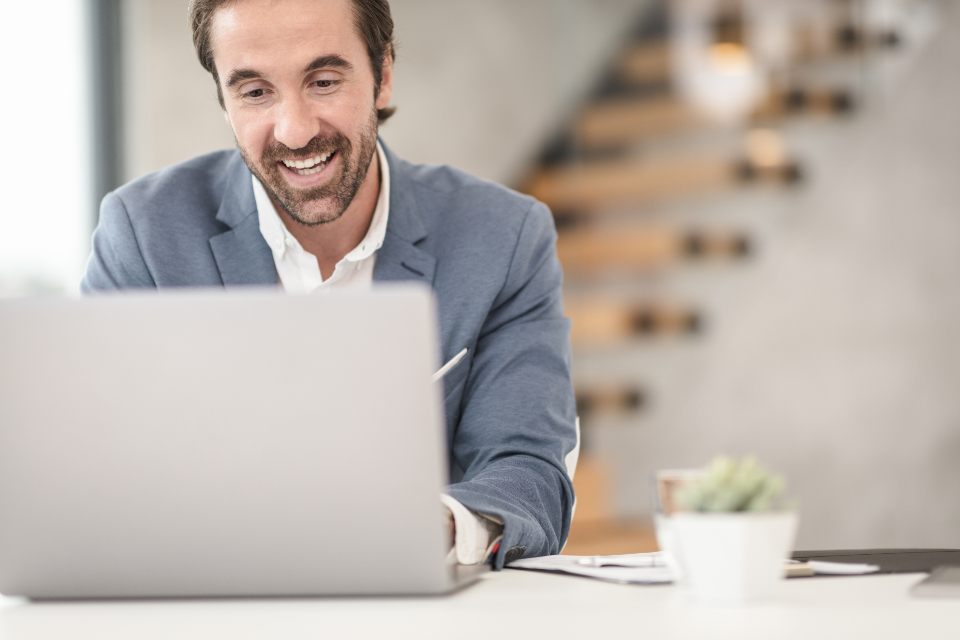 Indépendant souriant travaillant sur son ordinateur