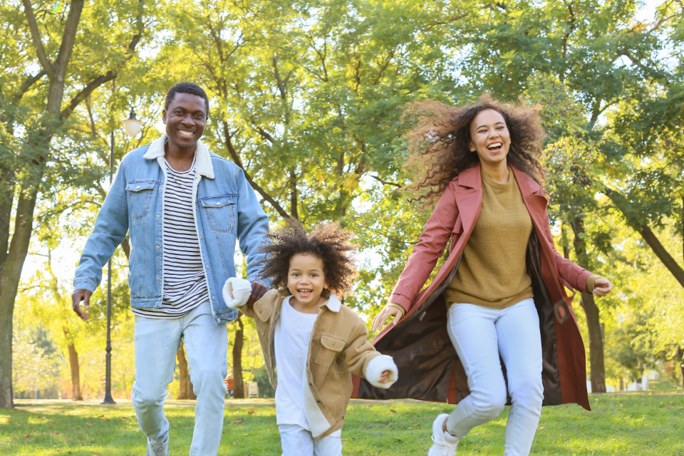 Parents et enfant qui courent dans un parc